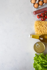Delivery of food products during the period of isolation. Food supplies from an online store pasta, oil, eggs, salad. Donation, coronavirus quarantine.Flat lay, copy space white background composition