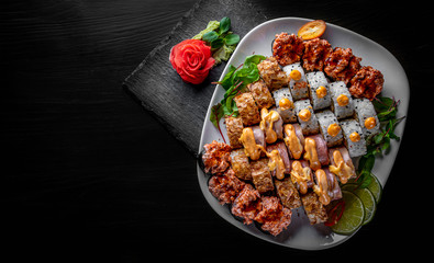 set of sushi roll with salmon, avocado, cream cheese, cucumber, rice, caviar, eel, tuna in plate on black wooden table background