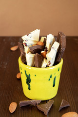 Pieces of white and black chocolate in a yellow glass