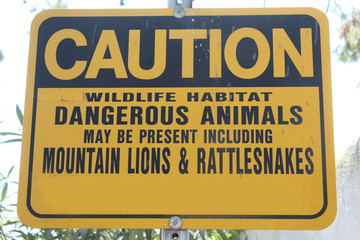 écriteau signalant la présence dangereuse possible  de serpents-à-sonnette et de pumas