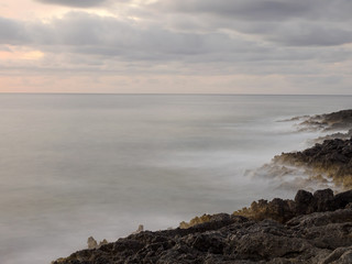 Sunset and waves crashing on the rocks