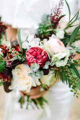 Close-up bouquet of flowers in women's hands. style, floral arranging, wedding concept.