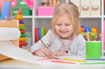 Beautiful little girl drawing at her room