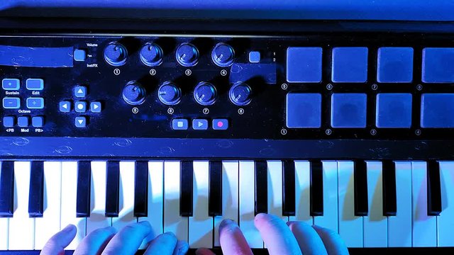 Male hands play customize the midi keyboard and play on the keys