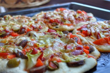 Pizza was just taken out of the oven on a tray close-up.