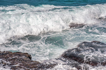 abstract background of sea surf on a rocky shore in clear windy weather