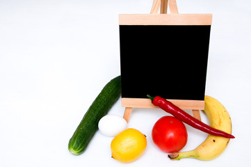 Slate, tomatoes, banana, red paper, lemon, egg and cucumber on white background. Cooking at home concept. Vegetables and fruits. Ingredients. Food shopping. Healthy food concept. Copy space 