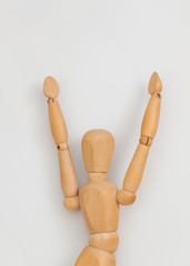 wooden mannequin raising both hands