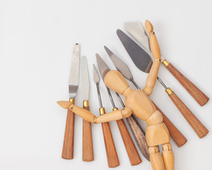 a wooden mannequin with spatulas