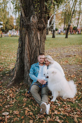 Young couple are relaxing outdoors with their cute dog