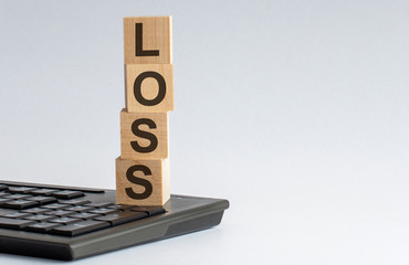 Wooden cubes with word LOSS on wooden table. Financial loss or unprofitable busines ventures concept. on the keyboard background - obrazy, fototapety, plakaty