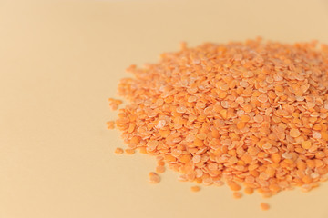 Pile red lentils on a light background, close-up, copy space for text.