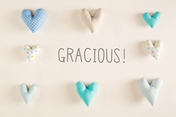 Gracious - Thank you in Spanish language with blue heart cushions on a white paper background