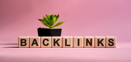 Back link donor - business concept on a pink background. Wooden cubes and flower