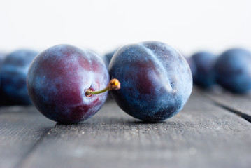 plums on black wood table, front view