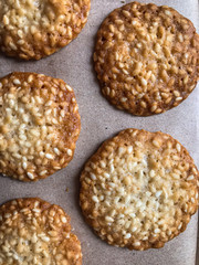  свежее домашнее печенье с кунжутом на бумаге для выпекания