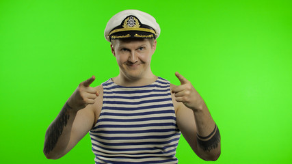 Young sailor man pointing to camera with hands. Seaman guy in sailor's vest