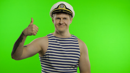 Young sailor man thumbs up, looking at camera. Seaman guy in sailor's vest