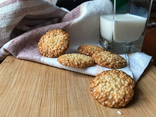 домашнее печенье и стакан молока на полотенце и деревянной доске