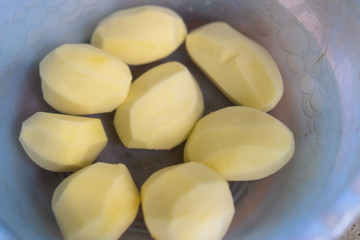 Peeled whole potato in water