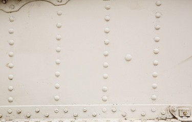 Old silver metal surface of the aircraft fuselage with rivets. Iron plate,steel sheet texture,pattern and background. Aluminum surface of the aircraft fuselage. Smooth rows of rivets.