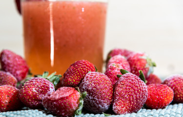 Strawberry juice (Fragaria × ananassa) and frozen fruits on white background