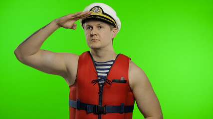 Young muscular sailor man works as lifeguard at beach observe the territory