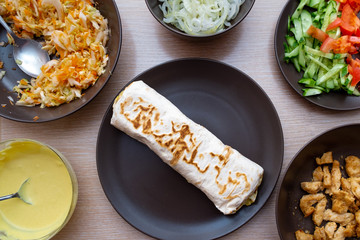 Shawarma lies in a pan. Cooking Shawarma. Nearby are some of the ingredients of this recipe. Step by step recipe