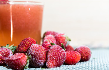 Strawberry juice (Fragaria × ananassa) and frozen fruits on white background