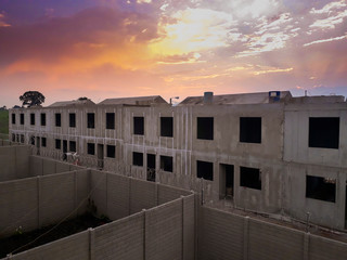 Serial construction of cast concrete homes on site, small family home in Guatemala, dramatic sunset.