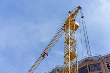 Fototapeta na wymiar Construction crane near the building against the sky