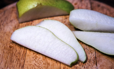 slices of fresh cut pear on wooden plate