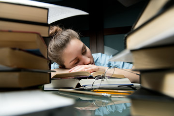 Preparing for university entrance. The girl fell asleep on stack of opened books