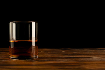 Glass of whiskey on a wooden table