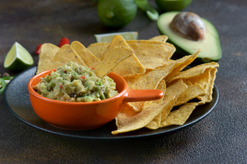 nachos and guacamole on a dark background