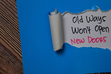 Old Ways Won't Open New Doors Text written in torn paper.
