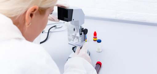 Woman working with a microscope in lab