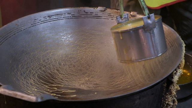 Cooking on a big pig traditional thai sweet khanom la krob in Thailand night market in slow motion
