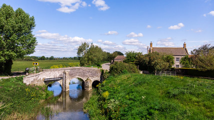 Fototapeta premium A pretty village cottage next to a countryside river in Somerset. 