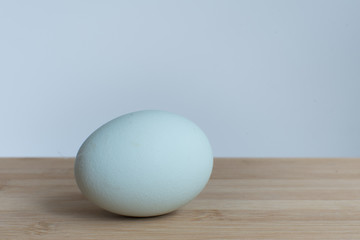 Natural blue shelled egg on wooden chopping board. Araucana chicken egg.