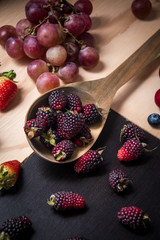 Blackberries and red fruits on a wooden surface