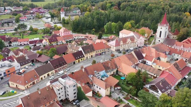 Aerial view of historical centre of Blatna in autumn day overlooking gothic church bell tower and ancient Water castle, South Bohemian Region, Czech Republic