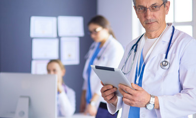 Portrait of a smiling doctor in his bright office