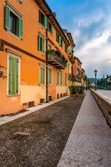 Fototapeta na wymiar A narrow walkway along the Adige River in Verona Italy