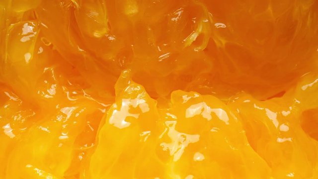 Squeezed juicy citrus.  Squeezing a fresh and juicy orange. Extreme close up.
