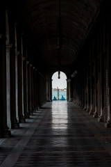 Fototapeta premium docked gondolas at the end of a beautiful archway in venice