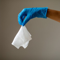 Throw a damp wet wipe into the trash, hand in blue protective glove