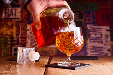 Cognac being poured from a decanter in to a glass in a bar ,restaurant.