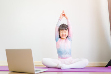 Video streaming Stay fit at home.home fitness workout class live streaming online.Asian kid girl in yoga gymnastics keep calm and fit.Online class live videos on laptop at home.New normal healthcare.