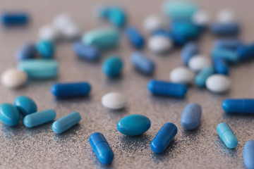 A lot of blue pills, capsules and tablets in selective focus